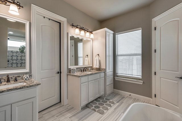 6470 Eyrie Bnd, Waxahachie, TX 75167 - bathroom with a freestanding bath, two vanities, and baseboards