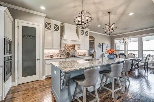 6470 Eyrie Bnd, Waxahachie, TX 75167 - kitchen with a sink, premium range hood, a chandelier, stainless steel appliances, and recessed lighting
