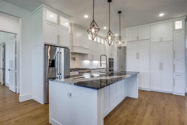 145 Chisolm Trl, Pottsboro, TX 75076 - kitchen featuring stainless steel appliances, wood finished floors, decorative backsplash, glass insert cabinets, and recessed lighting