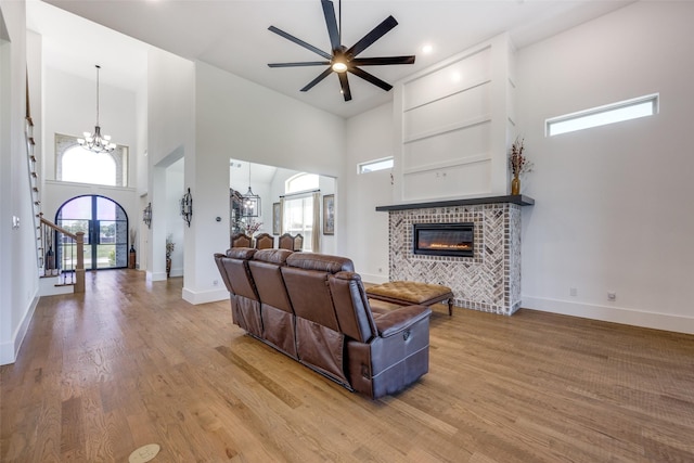 145 Chisolm Trl, Pottsboro, TX 75076 - living room featuring a chandelier, a high ceiling, a tile fireplace, wood finished floors, and a ceiling fan