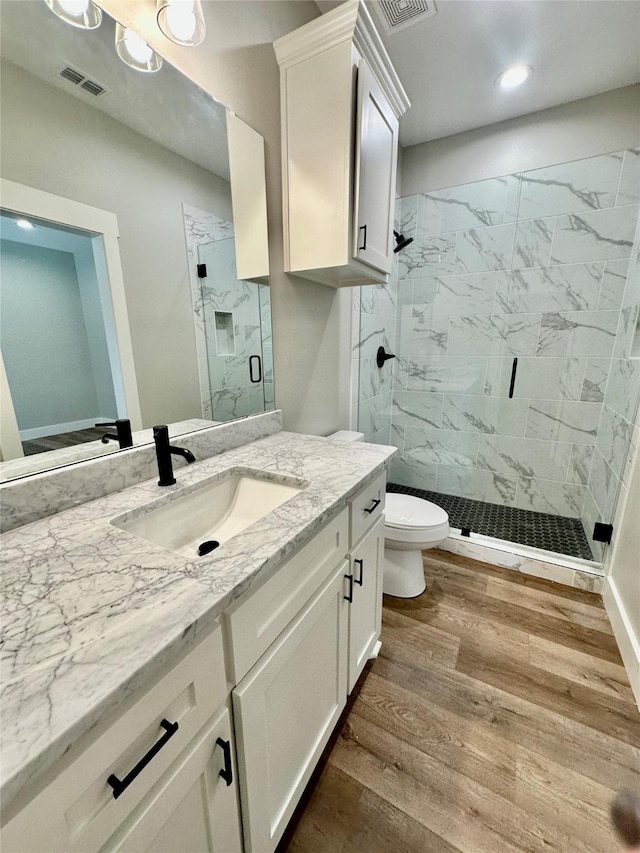 913 Carter, Sulphur Springs, TX 75482 - bathroom with a marble finish shower, wood finished floors, vanity, toilet, and recessed lighting