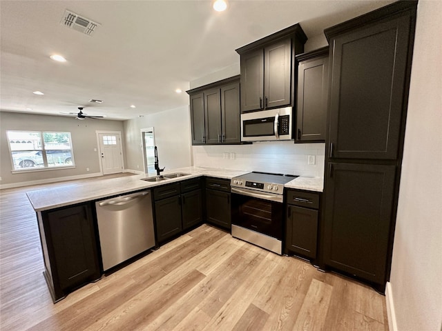 913 Carter, Sulphur Springs, TX 75482 - kitchen with stainless steel appliances, a sink, a peninsula, light wood finished floors, and a ceiling fan