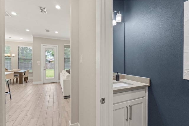 2027 Shaw St, Dallas, TX 75212 - bathroom featuring vanity, baseboards, recessed lighting, wood finished floors, and ornamental molding