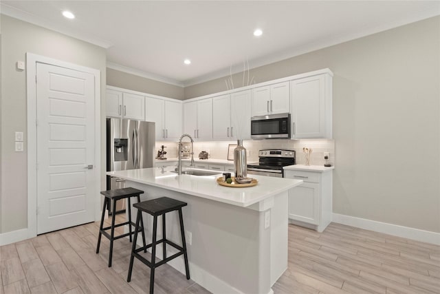 2027 Shaw St, Dallas, TX 75212 - kitchen featuring appliances with stainless steel finishes, a sink, decorative backsplash, a breakfast bar, and light countertops