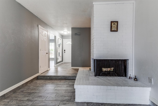 2929 Forest Park Dr, Garland, TX 75040 - living room with a textured ceiling, a brick fireplace, and baseboards