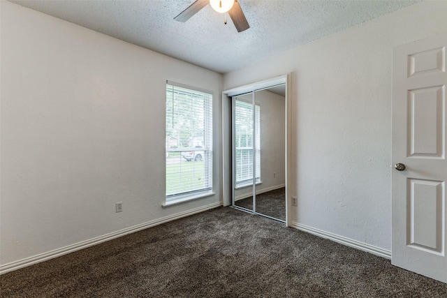 2929 Forest Park Dr, Garland, TX 75040 - unfurnished bedroom with dark carpet, a textured ceiling, a closet, a ceiling fan, and baseboards