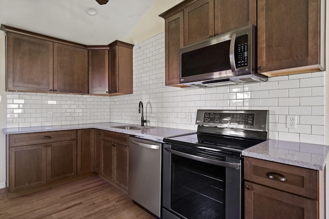 4104 Meandering Ct, Lakeside, TX 76135 - kitchen featuring stainless steel appliances, a sink, light wood-style flooring, light stone counters, and backsplash