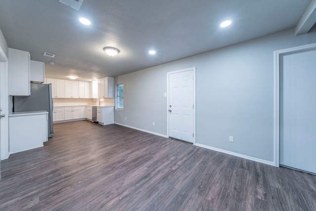 1725 Camara Ct, Grand Prairie, TX 75051 - unfurnished living room featuring dark wood-style flooring, recessed lighting, baseboards, and a sink