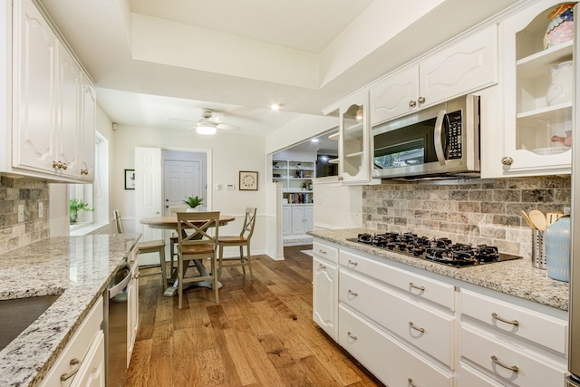 kitchen featuring stainless steel appliances, white cabinetry, and decorative backsplash
