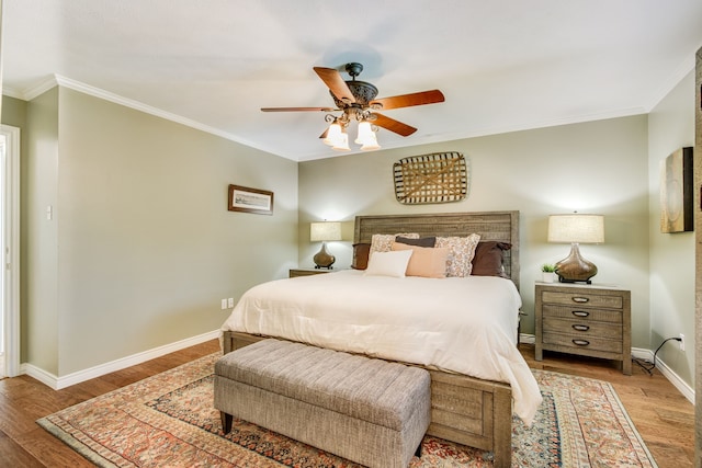bedroom featuring wood finished floors, baseboards, crown molding, and a ceiling fan