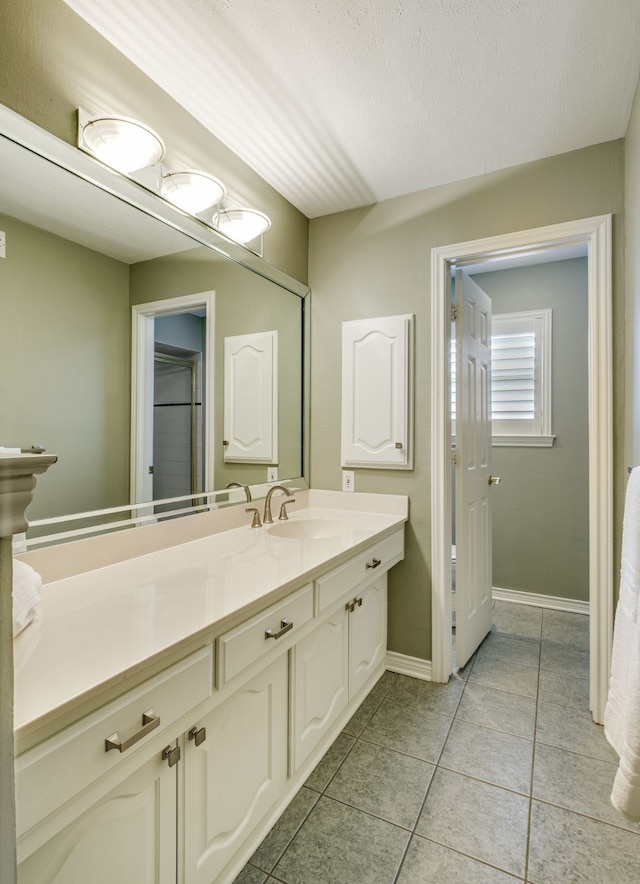 bathroom featuring vanity, tile patterned flooring, and baseboards