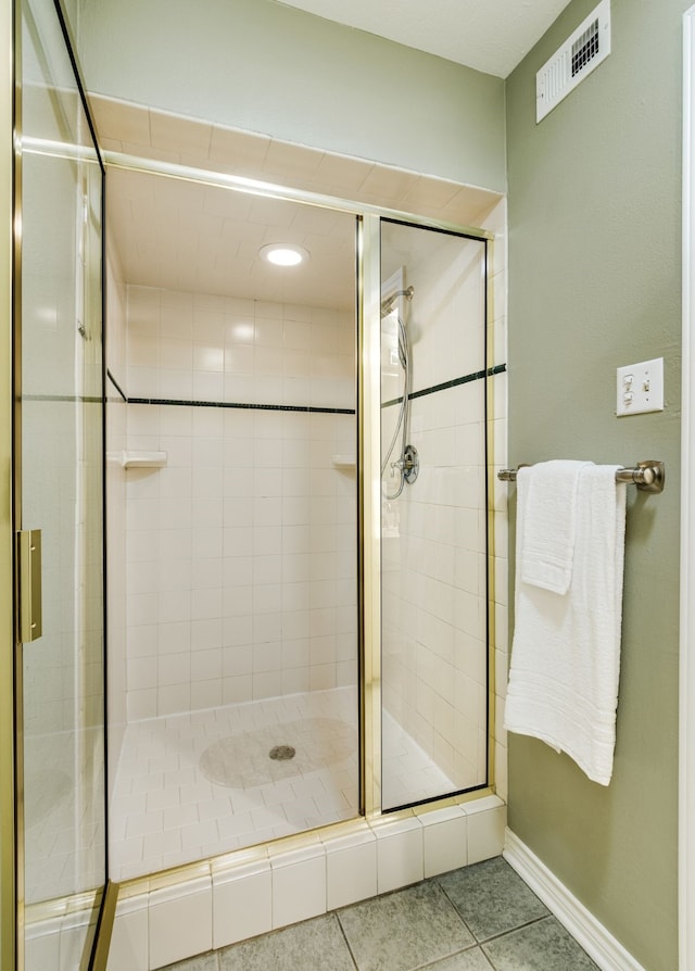 bathroom with a shower stall, tile patterned flooring, baseboards, and recessed lighting