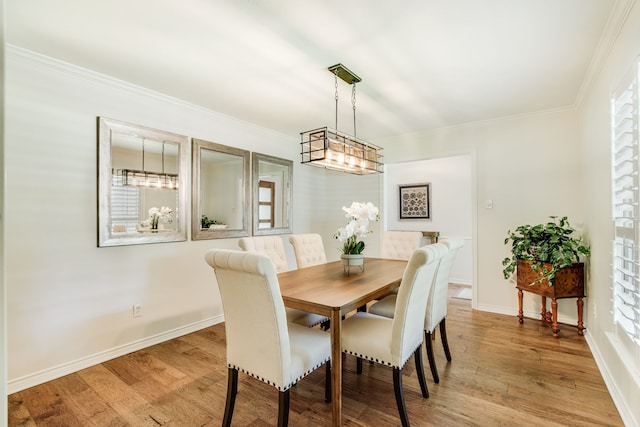dining area with crown molding, light wood-style flooring, and baseboards