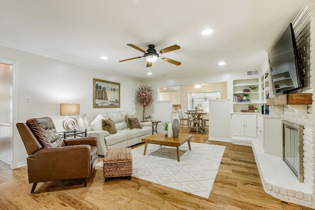 living area with ceiling fan, light wood finished floors, ornamental molding, recessed lighting, and baseboards