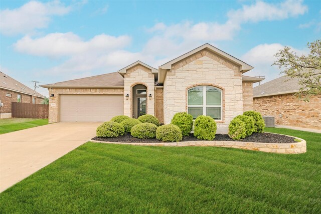 7314 Boulder Star Way, Temple, TX 76502 - view of front facade with an attached garage, driveway, stone siding, and central air condition unit