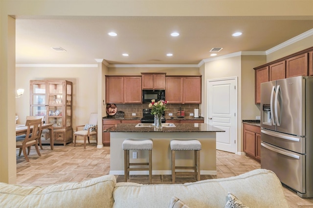 7314 Boulder Star Way, Temple, TX 76502 - kitchen with stainless steel fridge, black microwave, a kitchen island, recessed lighting, and decorative backsplash