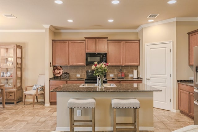 7314 Boulder Star Way, Temple, TX 76502 - kitchen featuring black microwave, a sink, an island with sink, dark stone counters, and recessed lighting