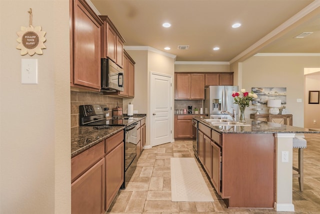 7314 Boulder Star Way, Temple, TX 76502 - kitchen with appliances with stainless steel finishes, a kitchen bar, a sink, tasteful backsplash, and an island with sink