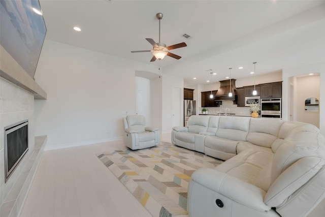 11130 Villa Canales Ln, Frisco, TX 75035 - living room with a ceiling fan, a tile fireplace, recessed lighting, light wood-style flooring, and baseboards