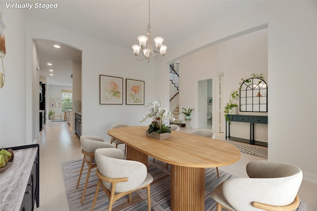 11130 Villa Canales Ln, Frisco, TX 75035 - dining area featuring arched walkways, recessed lighting, stairway, light wood-style flooring, and a chandelier