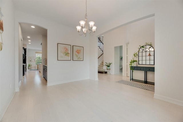 11130 Villa Canales Ln, Frisco, TX 75035 - corridor featuring arched walkways, recessed lighting, stairway, light wood-style floors, and a chandelier