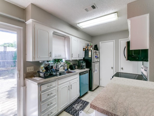 508 Billie Ruth Ln, Hurst, TX 76053 - kitchen featuring appliances with stainless steel finishes, white cabinetry, a textured ceiling, light countertops, and a sink