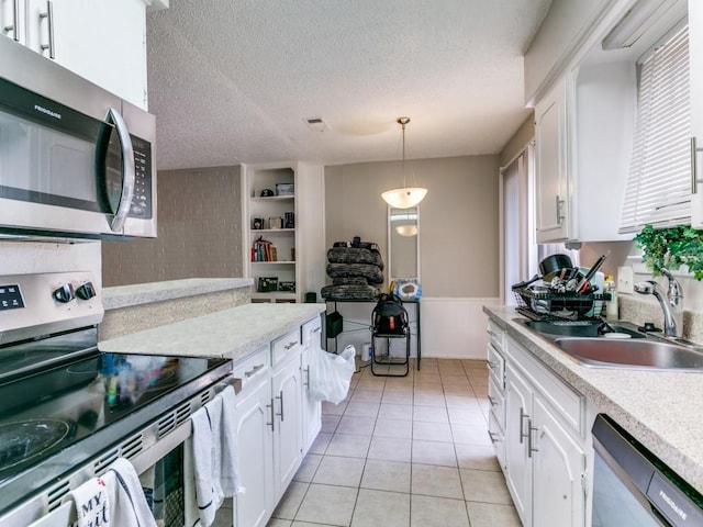 508 Billie Ruth Ln, Hurst, TX 76053 - kitchen with appliances with stainless steel finishes, a sink, light countertops, white cabinets, and a textured ceiling