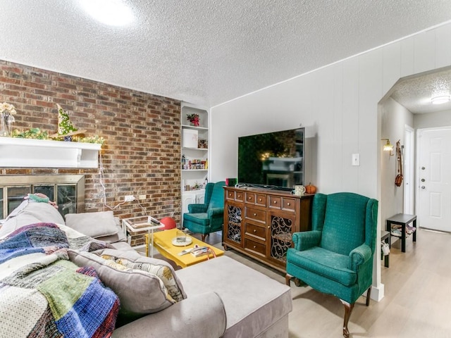508 Billie Ruth Ln, Hurst, TX 76053 - living room featuring brick wall, a textured ceiling, wood finished floors, arched walkways, and a fireplace