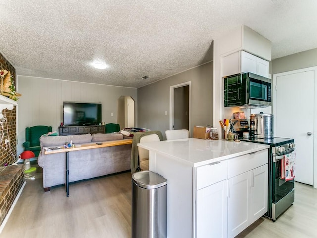 508 Billie Ruth Ln, Hurst, TX 76053 - kitchen with stainless steel appliances, light wood-style floors, white cabinetry, a textured ceiling, and light countertops