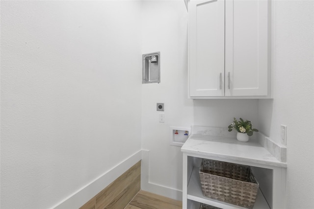 401 Tangle Dr, Tool, TX 75143 - laundry area featuring cabinet space, hookup for an electric dryer, washer hookup, light wood-style flooring, and baseboards