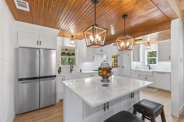 401 Tangle Dr, Tool, TX 75143 - kitchen with freestanding refrigerator, wood ceiling, a sink, a chandelier, and backsplash