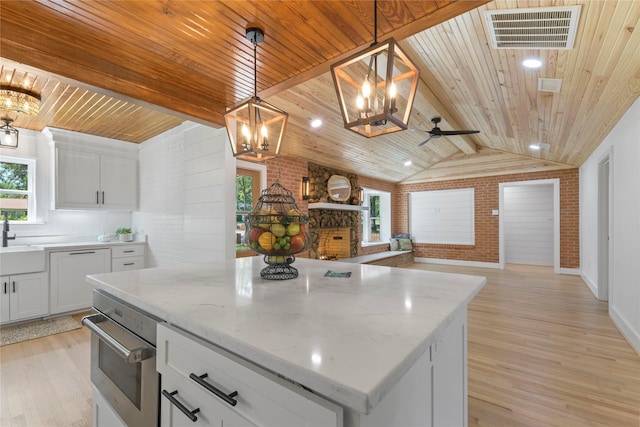401 Tangle Dr, Tool, TX 75143 - kitchen with open floor plan, stainless steel oven, a chandelier, brick wall, and wooden ceiling