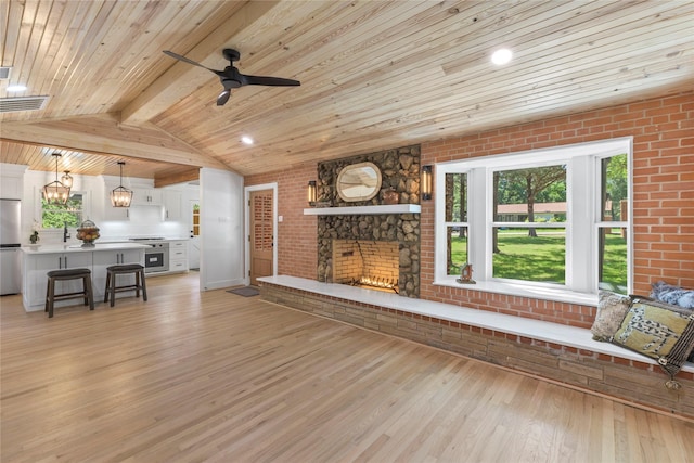 401 Tangle Dr, Tool, TX 75143 - living area with light wood-style floors, wood ceiling, ceiling fan, a fireplace, and brick wall