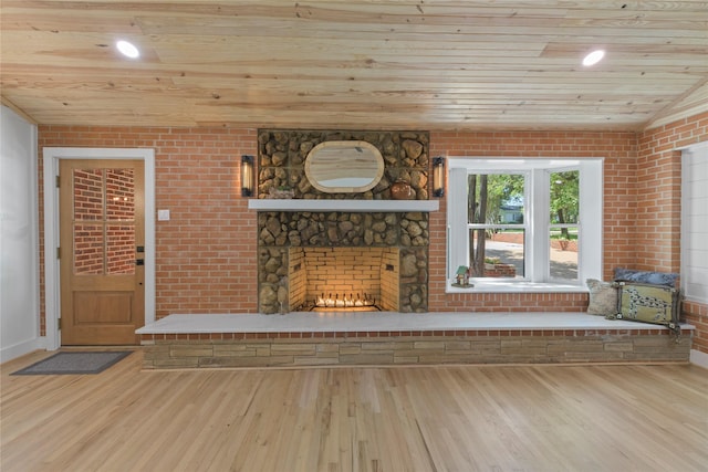 401 Tangle Dr, Tool, TX 75143 - unfurnished living room featuring wood ceiling, brick wall, wood finished floors, a stone fireplace, and baseboards