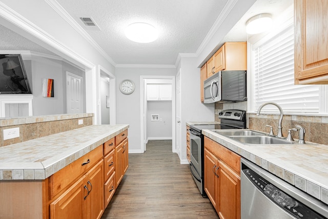 7510 County Road 118, Kaufman, TX 75142 - kitchen with stainless steel appliances, a sink, dark wood-style flooring, tasteful backsplash, and light countertops
