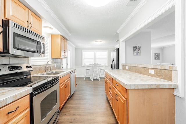 7510 County Road 118, Kaufman, TX 75142 - kitchen with appliances with stainless steel finishes, a sink, light wood-style flooring, crown molding, and tasteful backsplash