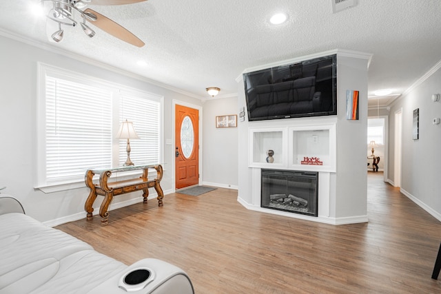 7510 County Road 118, Kaufman, TX 75142 - living area with a ceiling fan, ornamental molding, wood finished floors, a textured ceiling, and baseboards