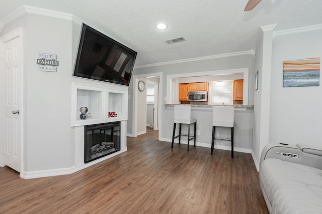 7510 County Road 118, Kaufman, TX 75142 - living area featuring wood finished floors, ceiling fan, baseboards, crown molding, and a textured ceiling