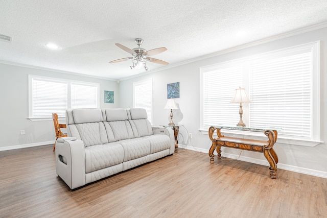 7510 County Road 118, Kaufman, TX 75142 - living area featuring ornamental molding, ceiling fan, baseboards, light wood finished floors, and a textured ceiling