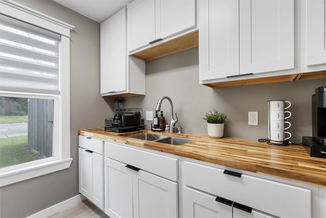 1900 N 15th St, Waco, TX 76707 - kitchen with wooden counters, a sink, and white cabinetry