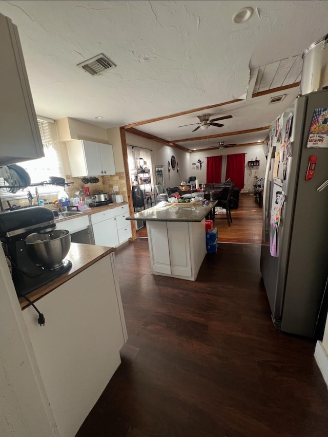 1248 E Allen Ave, Fort Worth, TX 76104 - kitchen with freestanding refrigerator, dark wood-type flooring, white cabinets, and ceiling fan