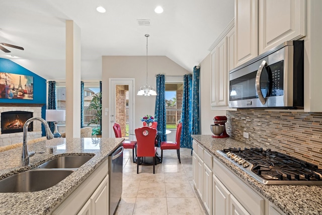 1109 Hot Springs Way, Celina, TX 75009 - kitchen with stainless steel appliances, a sink, lofted ceiling, decorative backsplash, and a chandelier
