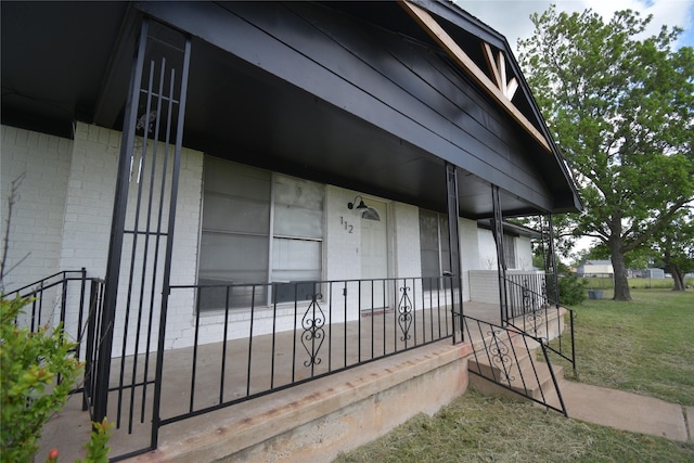 112 Big Bass Rd, West, TX 76691 - doorway to property with brick siding, a porch, and a lawn