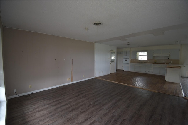 112 Big Bass Rd, West, TX 76691 - unfurnished living room featuring a sink, dark wood-style floors, and baseboards