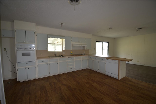 112 Big Bass Rd, West, TX 76691 - kitchen featuring white appliances, a sink, dark wood finished floors, under cabinet range hood, and a peninsula