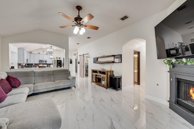 2775 Sweetbriar Ln, Grand Prairie, TX 75052 - living room with arched walkways, a barn door, a glass covered fireplace, a chandelier, and vaulted ceiling