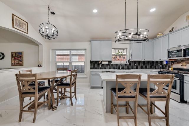 2775 Sweetbriar Ln, Grand Prairie, TX 75052 - kitchen with appliances with stainless steel finishes, a chandelier, light marble finish floors, lofted ceiling, and recessed lighting