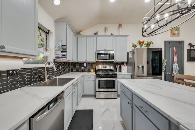 2775 Sweetbriar Ln, Grand Prairie, TX 75052 - kitchen featuring appliances with stainless steel finishes, a sink, gray cabinets, decorative backsplash, and lofted ceiling