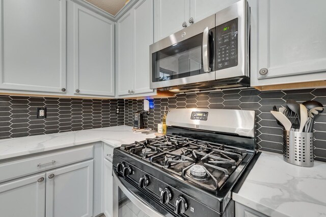 2775 Sweetbriar Ln, Grand Prairie, TX 75052 - kitchen featuring appliances with stainless steel finishes, backsplash, light stone countertops, and white cabinetry