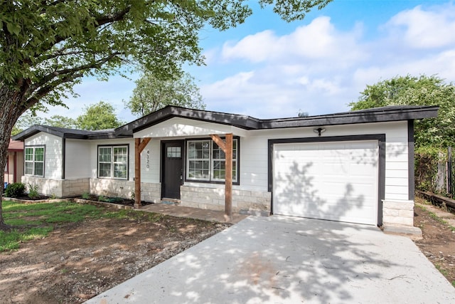 4320 Carmel Ave, Fort Worth, TX 76119 - single story home featuring a garage, driveway, and stone siding